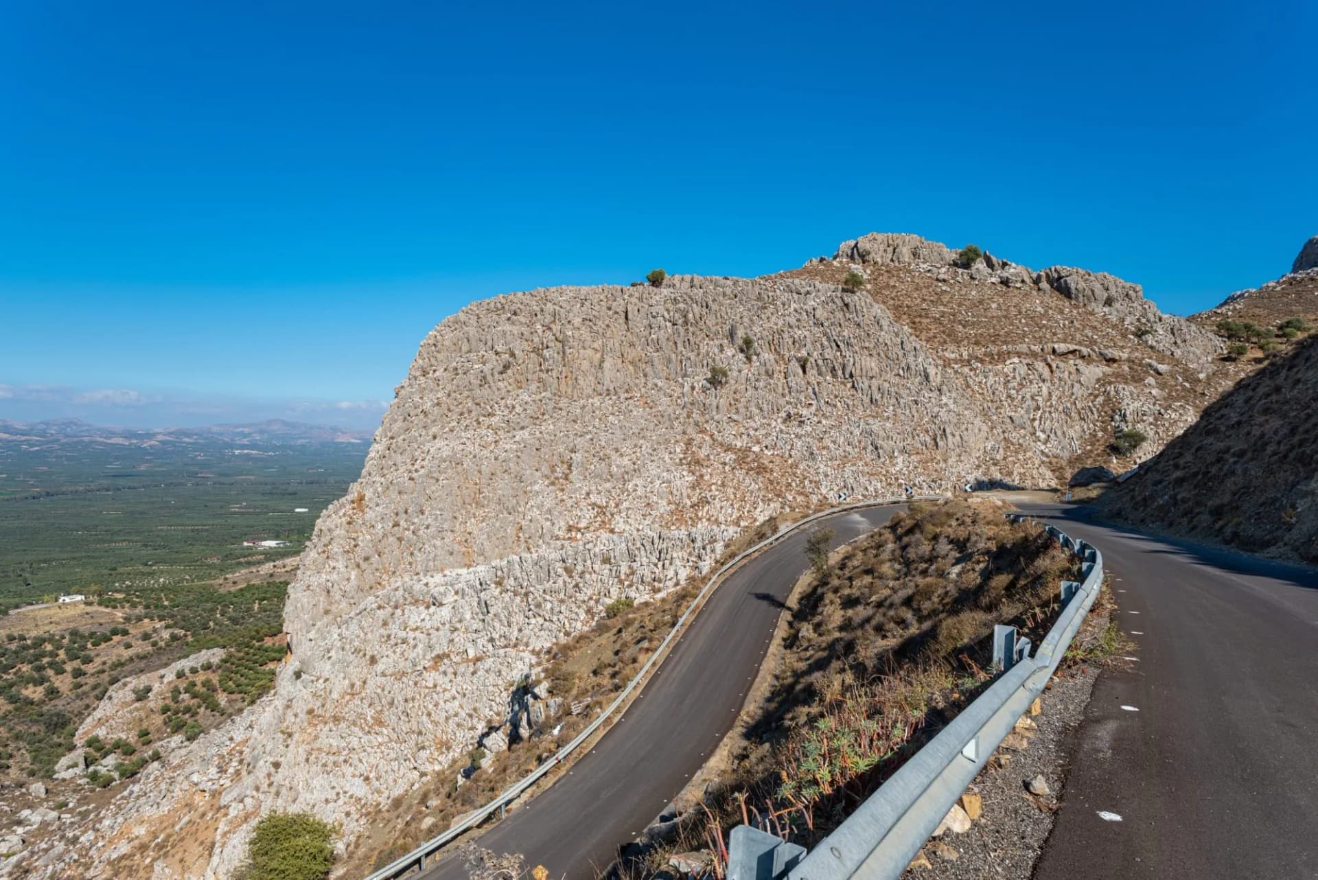 Huge rock at the hairpin turn on the way crossing the  Asterousia mountains  to Lentas. Scenic outlook to the great Messara plain in the south of Crete