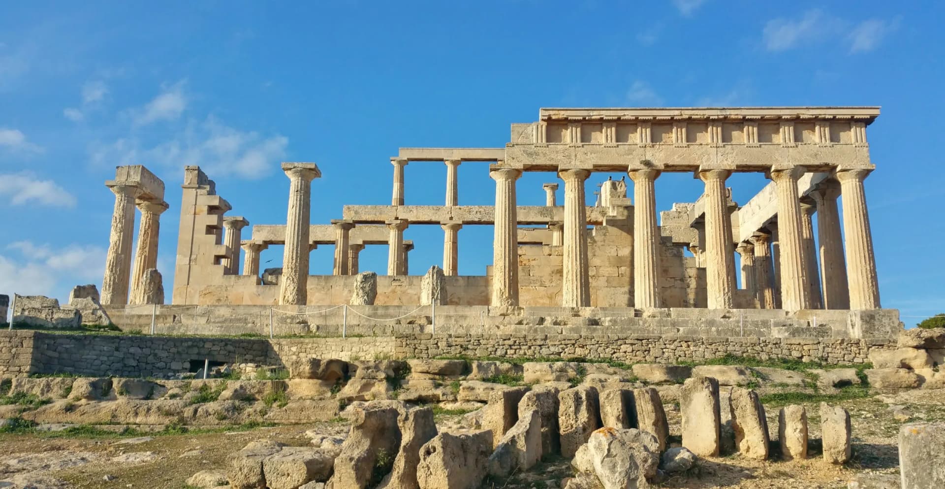 Greek ruins at the Temple of Aphaia on the island of Egina (Saronic Islands Aegean Sea) ancient roman columns, blue sky golden hour soft light (goddess monument) historic remains, Greece Mediterranean