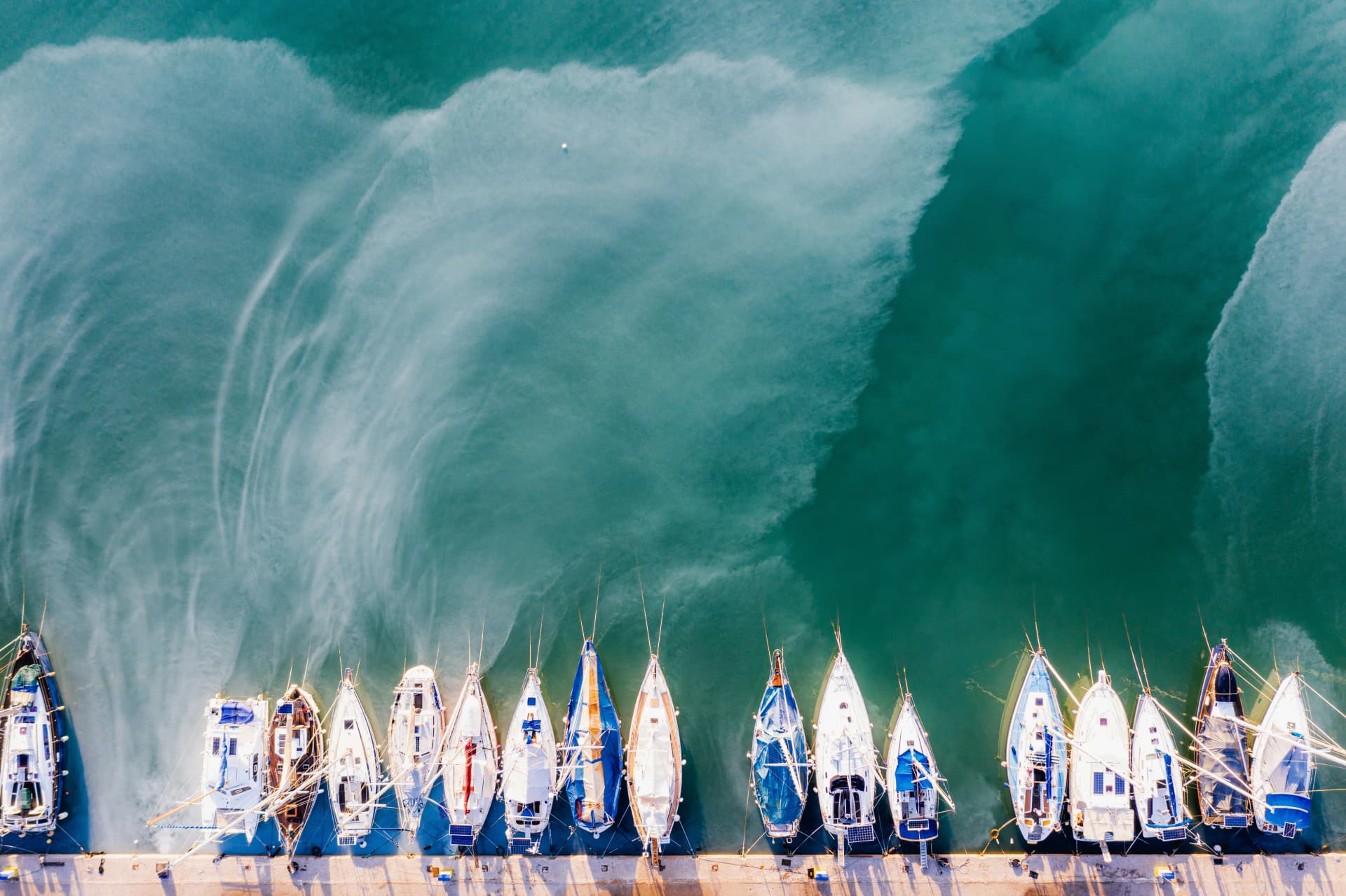 Hot spring and boats in the harbor of town of Methana, Greece